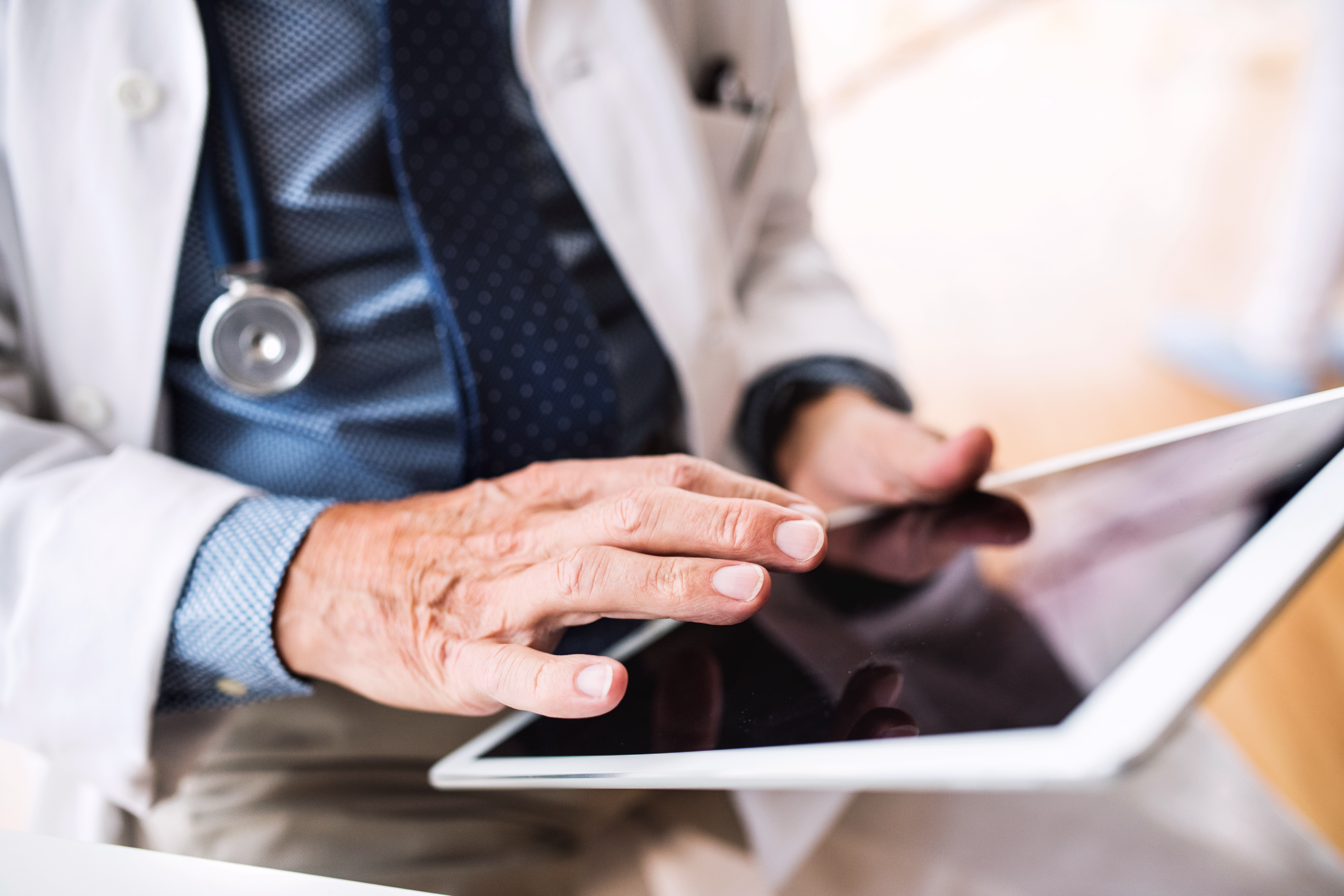 senior-doctor-with-tablet-working-at-the-office-pe5p43n.png
