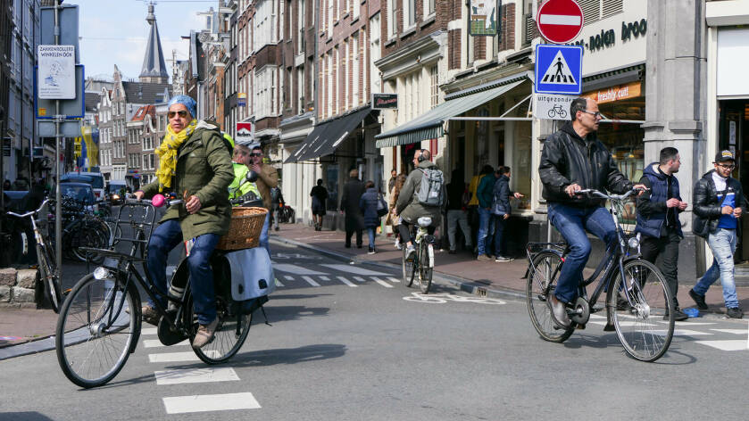 winkelstraat met fietsers en winkelende mensen